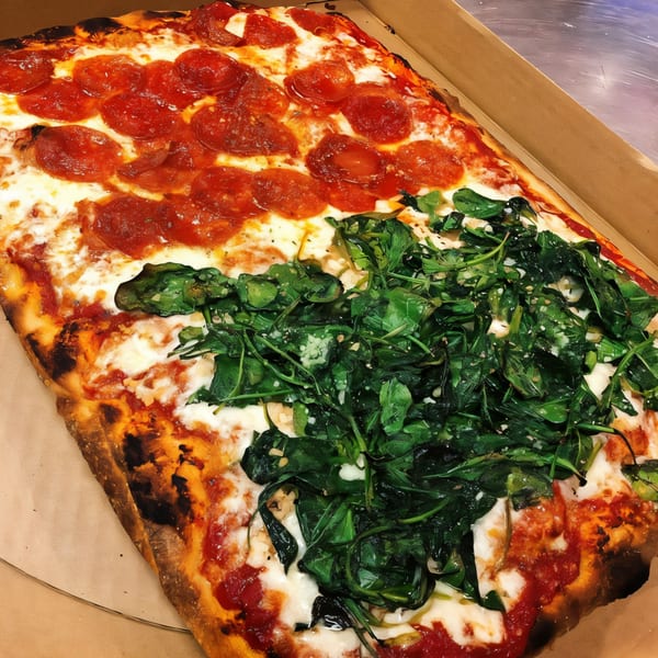 A rectangular J&M Italian American Cuisine pizza, half pepperoni and half spinach, in a cardboard box.
